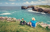 Pilgrims resting with a view of the coast on the Northern Way of Saint James