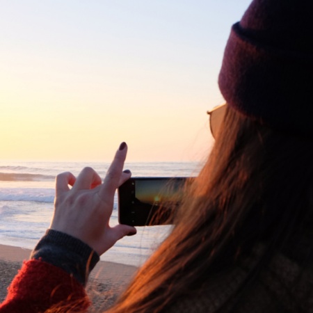 Junge Frau fotografiert den Sonnenuntergang