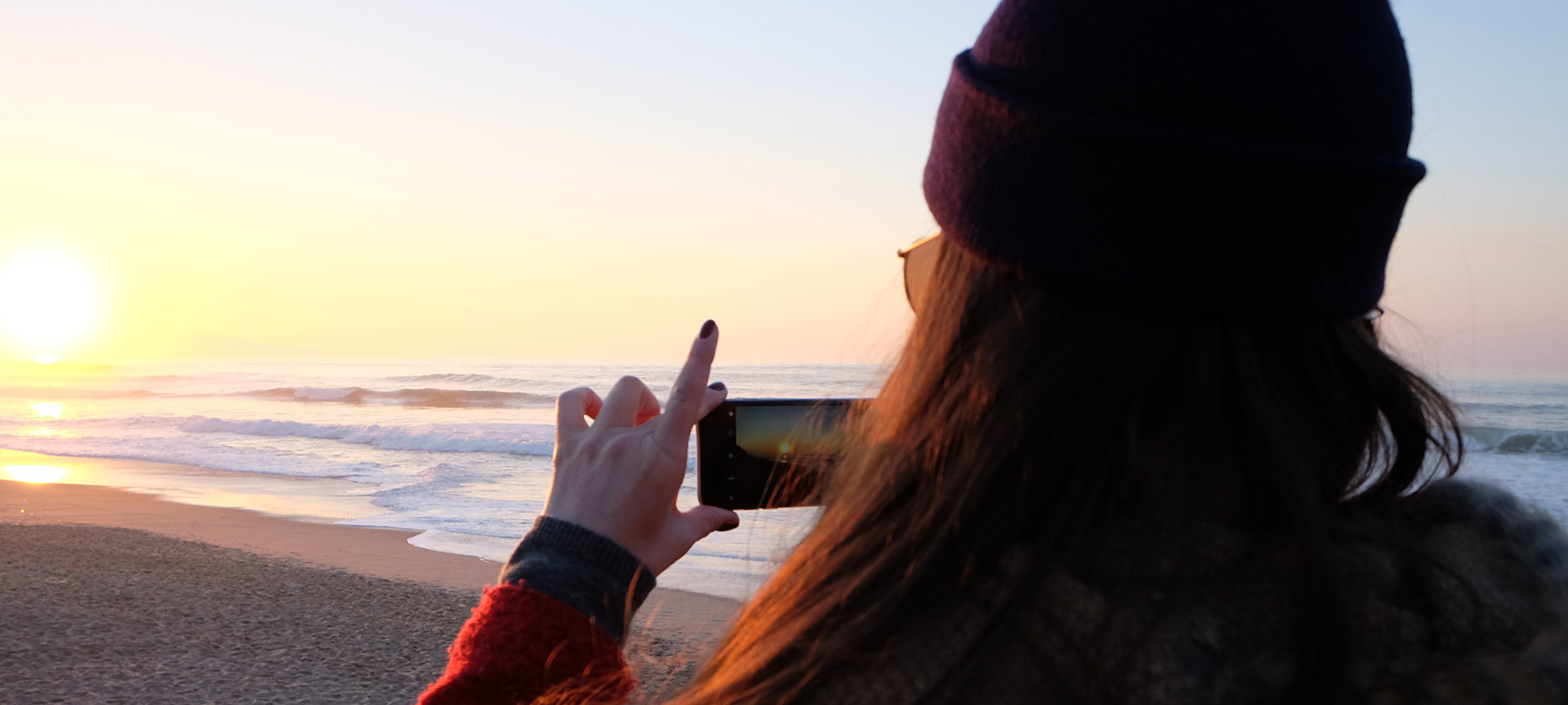 Une jeune fille prend une photo au coucher de soleil Une jeune fille prend une photo au coucher de soleil