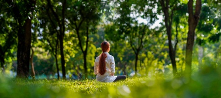 Mujer practicando meditación en el bosque