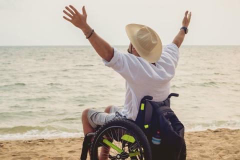 Personne handicapée en fauteuil roulant sur la plage