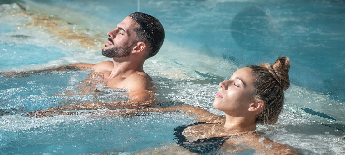 Couple relaxing in a jacuzzi in the Balneario de Las Caldas spa, Cantabria, Spain