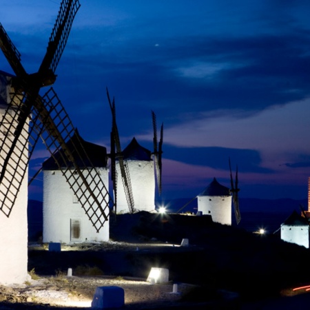Vista nocturna de los molinos de viento con el castillo de Consuegra al fondo. Toledo