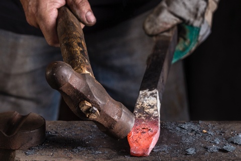 Craftsman working on a sword in a workshop in Toledo.