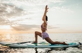 Femme faisant du yoga sur une planche Sup
