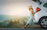 Turista appoggiata all'auto che si riposa durante il viaggio