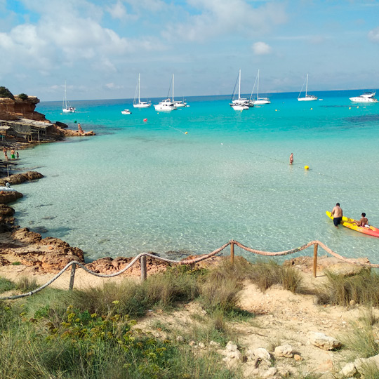 Vedute degli scogli e di piccole imbarcazioni storiche a Cala Saona, Formentera 