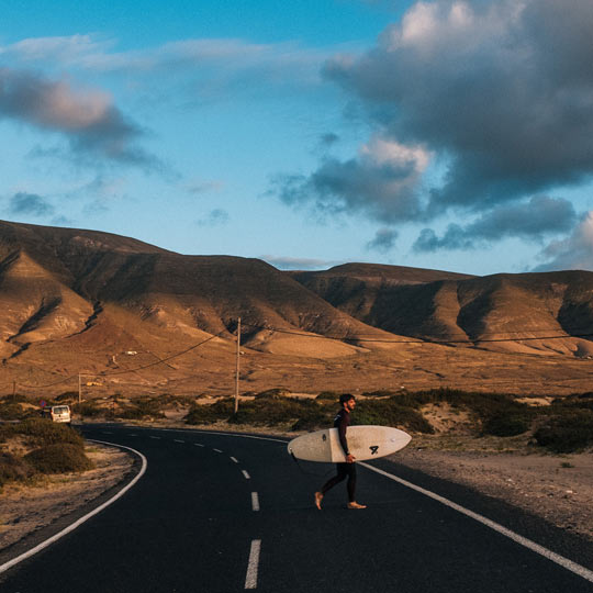 Surfeur sur une route de Lanzarote (îles Canaries).