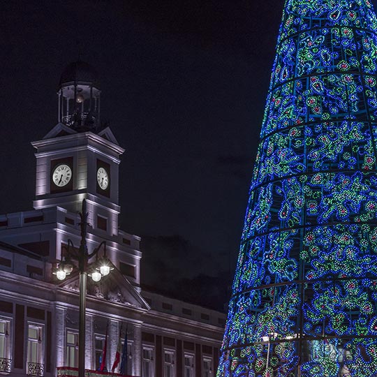 Detalhe da Puerta del Sol de Madri e a árvore iluminada no Natal