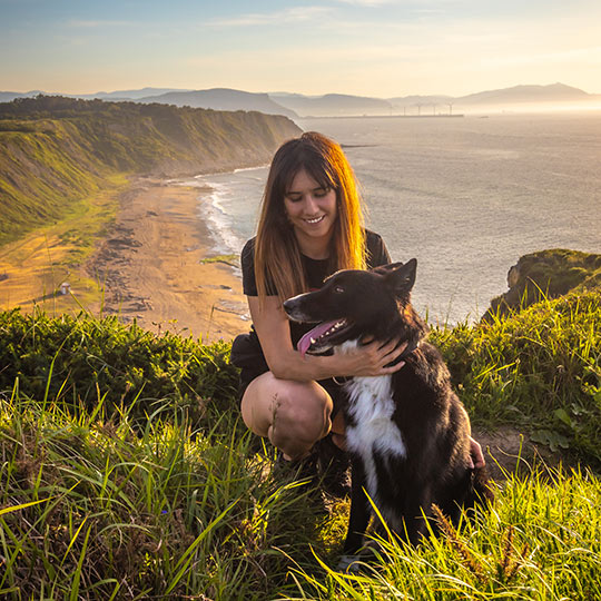 Jeune fille sur la côte basque caressant son animal de compagnie, Pays basque