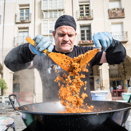 Membro de um grupo preparando migas durante as Festas da Vindima de La Rioja em Logroño, La Rioja