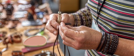 Artigiano che realizza bracciali in pelle