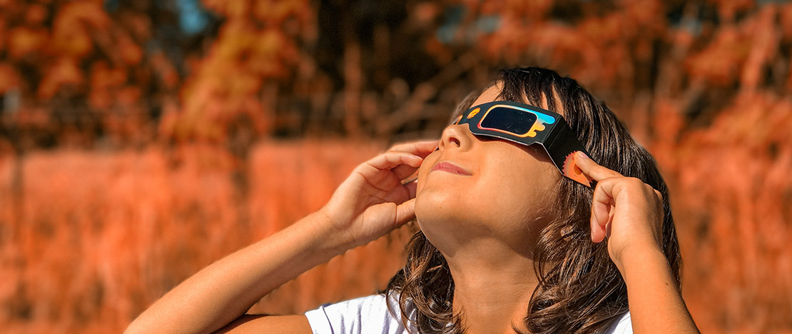 Niña mirando con gafas el eclipse solar Niña mirando con gafas el eclipse solar