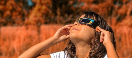 Niña mirando con gafas el eclipse solar