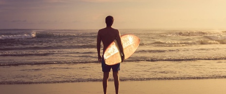 Surfer contemplating the waves from the shore