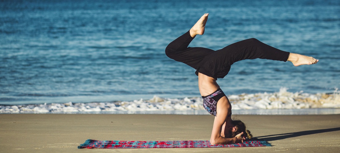 Frau beim Yoga am Strand