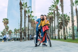 Tourists on bikes on the Barceloneta promenade in Barcelona, Catalonia